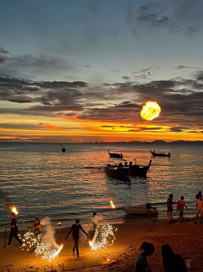 Fire dancers on the beach at sunset